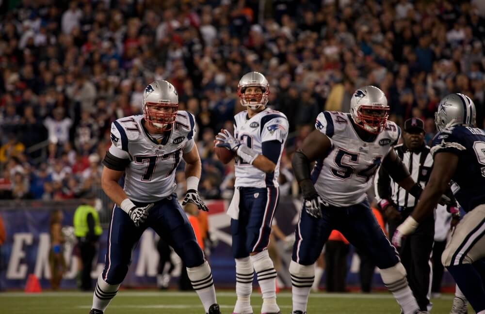 Tom Brady, No 12, prepares to throw pass
